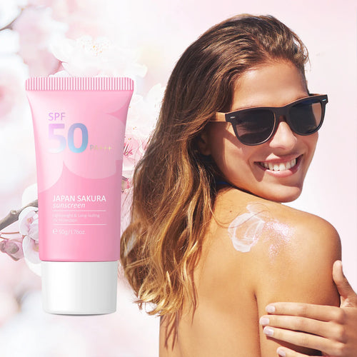 Woman applying sunscreen with a pink SPF 50 sunscreen tube in the foreground