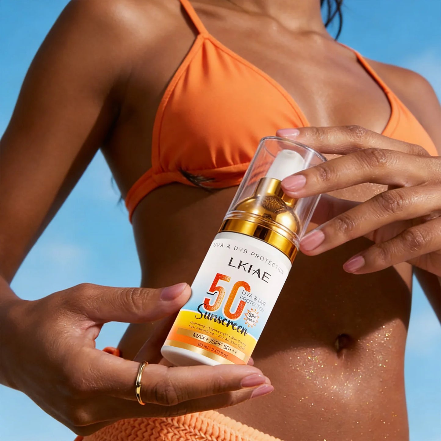 Person holding a bottle of LKIAE sunscreen with a blue sky background